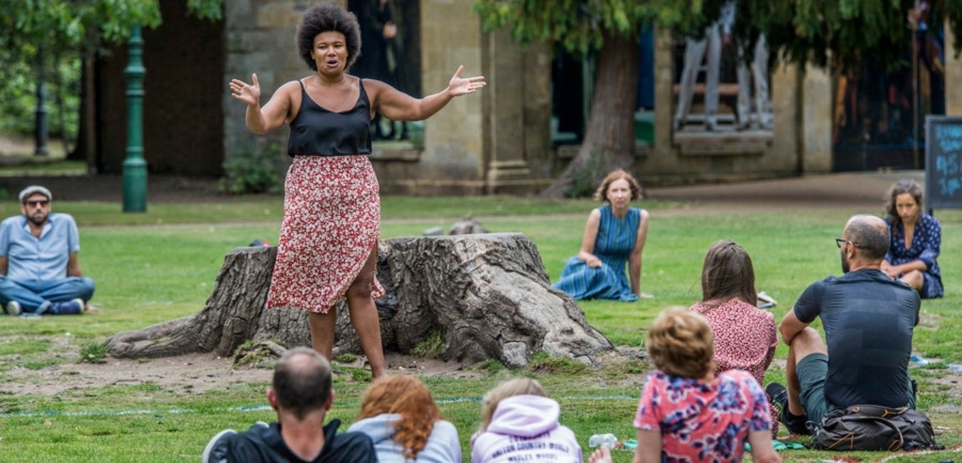 Actor performing outside to socially distanced audience