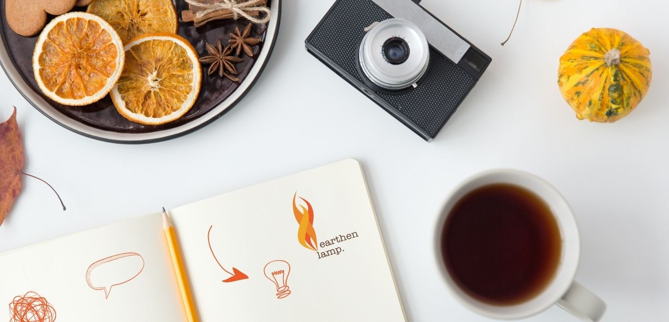 Table with notepad, coffee cup, camera and pumpkins