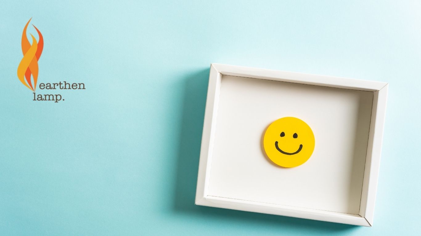 BLue background with Earthen Lamp logo and yellow smiling face in a wide picture frame