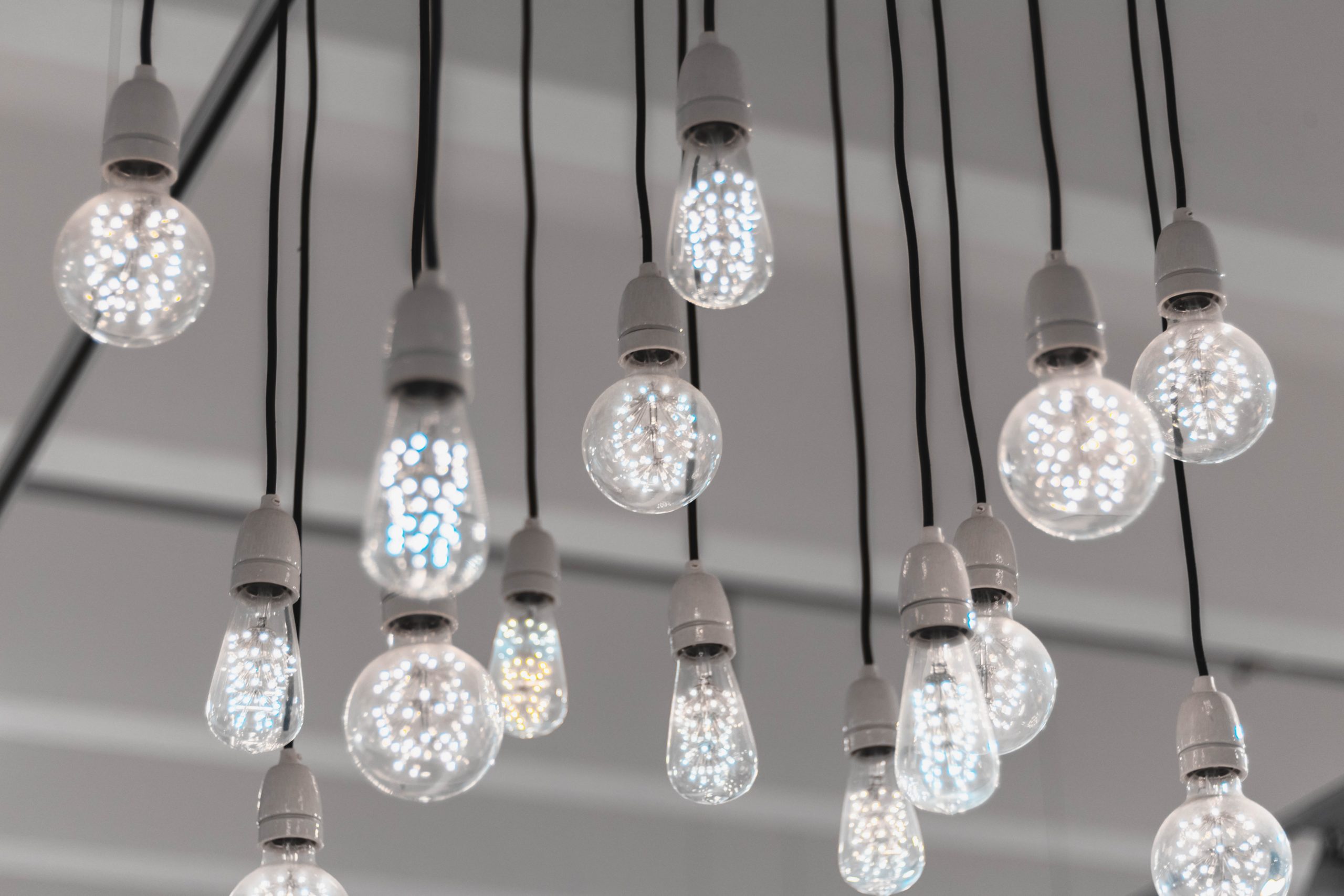 A selection of lit up lightbulbs hanging from the ceiling